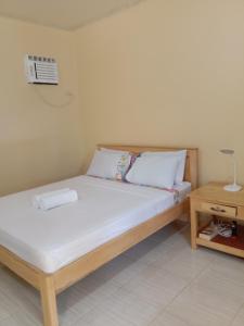 a bedroom with a bed and a table with a fan at Uptown Guesthouse in Siquijor
