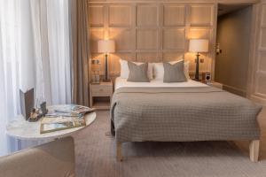 a bedroom with a large bed and a table at The Scotsman Hotel in Edinburgh