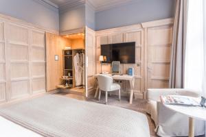 a room with a bed and a desk and a television at The Scotsman Hotel in Edinburgh