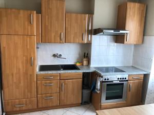 a kitchen with wooden cabinets and a stove top oven at Monteur Suite Rodenbach in Rodenbach