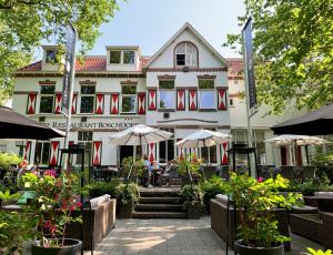 ein Gebäude mit roten und weißen Flaggen davor in der Unterkunft Fletcher Hotel Restaurant Boschoord in Oisterwijk
