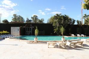 a swimming pool with lounge chairs and a resort at Solar das Mangueiras in Barreiras
