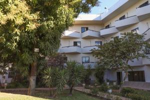 an apartment building with trees in front of it at Solar das Mangueiras in Barreiras