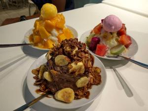 two plates of food on a table with desserts at Homestay De MITC Melaka 8 to 10 pax in Malacca