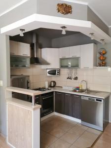 a kitchen with white and gray cabinets and appliances at Big and Spacious Apartment in the heart of Omi&scaron; in Omi&scaron;