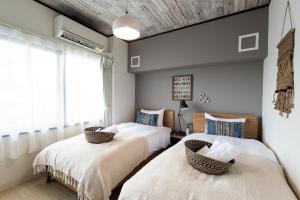 宜野灣的住宿－Little Santa，一间卧室设有两张床和窗户。