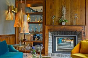 a living room with a fireplace and a blue couch at Domaine Du Roncemay - Les Collectionneurs in Aillant-sur-Tholon
