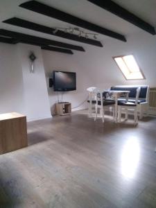 a room with a table and chairs and a tv at Gemütliche Wohnung Nähe Centro in Oberhausen