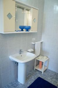 Residence Castello Otranto في أوترانتو: حمام مع حوض أبيض ومرآة