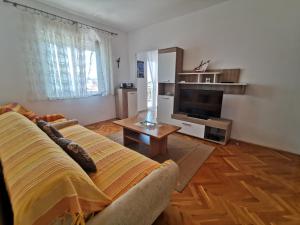 a living room with a couch and a television at Villa Clara apartments Kvarner in Novi Vinodolski