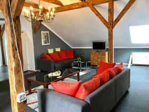 uma sala de estar com um sofá cinzento e almofadas vermelhas em Historic Apartments em Bremen-Vegesack
