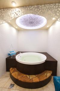a bathroom with a large bath tub in a room at Гостевой дом "Barkhat" in Izhevsk