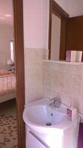 een badkamer met een wastafel en een spiegel bij B&B I Tre Bassotti in Loreto