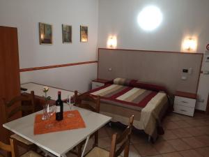 a room with a bed and a table with a bottle of wine at Ca' Del Sasso in Verona