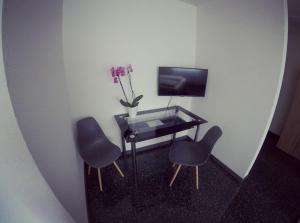 a room with a table and two chairs and a television at Gästezimmer Faut in Schorndorf