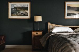 a bedroom with green walls and a bed with a lamp at Mackay's Rooms in Durness