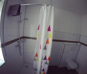 a bathroom with a shower curtain and a toilet at Gästezimmer Faut in Schorndorf