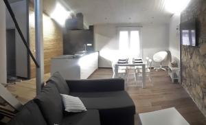 salon i kuchnia z kanapą i stołem w obiekcie Cal Dalmau Apartaments Átic w mieście Pardines