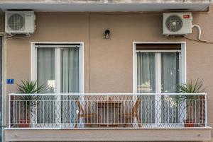 a balcony of a house with two windows at Colourful apt,airport line,6 min metro,100 MBPS! in Athens