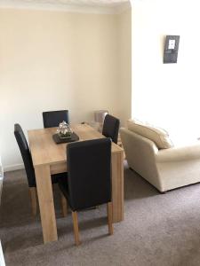 a dining room table with chairs and a couch at 10 Redcliffe in Stornoway