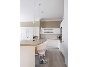 a kitchen with white cabinets and a island with stools at Sasha bel appartement renove centre ville Beaune in Beaune