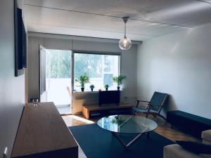 a living room with a glass table and a couch at Kalastajankuja Apartment in Espoo