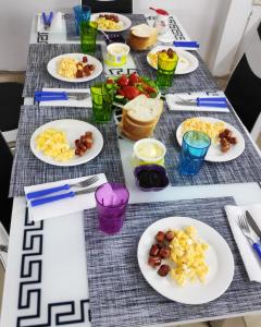 a table with plates of food on it at Tufina Hostel in Tirana