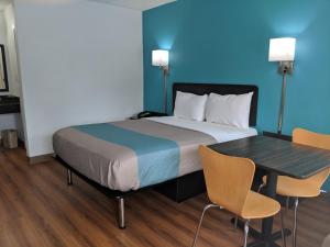 a bedroom with a bed and a table with chairs at Motel 6 Chattanooga - Airport in Chattanooga