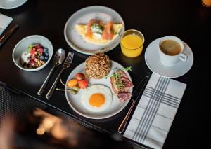 a table with plates of food and a cup of coffee at Clarion Hotel Oslo in Oslo