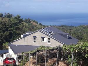 une maison avec un panneau solaire sur le toit dans l'établissement L'Eden des Colibris, à Vieux-Habitants