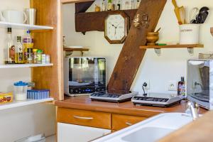 - un comptoir de cuisine avec évier et four micro-ondes dans l'établissement Le Sud, à Saint-Priest-sous-Aixe