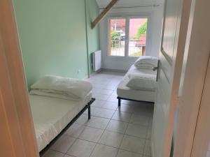 a room with two beds and a window at La grange de mémé Yvette in Vaulnaveys-le-Haut