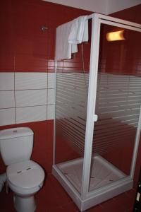 a bathroom with a toilet and a glass shower at Pensiunea All Seasons in Iaşi