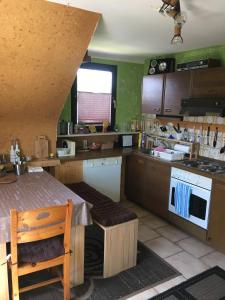 a kitchen with green walls and a table and a stove at Ferienwohnung Dippold in der fränkischen Schweiz in Heiligenstadt