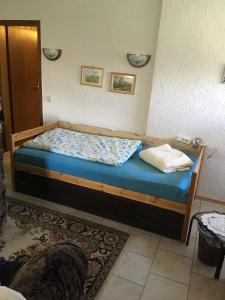 a bedroom with a wooden bed with a blue bedsheet at Ferienwohnung Dippold in der fränkischen Schweiz in Heiligenstadt