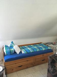 a bed with blue sheets and pillows in a room at Ferienwohnung Dippold in der fränkischen Schweiz in Heiligenstadt