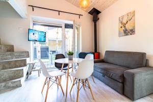 ein Wohnzimmer mit einer Couch und einem Tisch und Stühlen in der Unterkunft Life's a Beach Cottage in Palanga