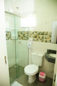a bathroom with a toilet and a glass shower at London Executive Hotel in Cafelândia +19 photos