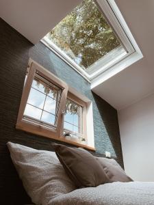 1 dormitorio con una gran ventana sobre una cama en Lytte Hytte - Ferienhaus Wingst, en Wingst