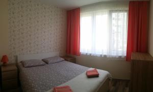 - une chambre avec un lit et une fenêtre avec des rideaux rouges dans l'établissement Orhidea Apartman, à Gheorgheni