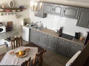 a kitchen with a table with a bowl of fruit on it at JOSSELIN CHURCH VIEW . in Josselin