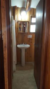 y baño con lavabo y espejo. en Complejo La Cautiva en Esquel