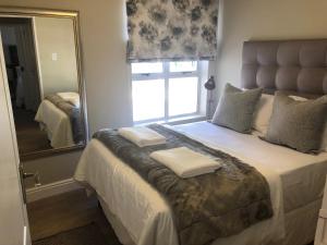 a bedroom with a bed with a large mirror at Summerseas 56 in Port Elizabeth +10 photos