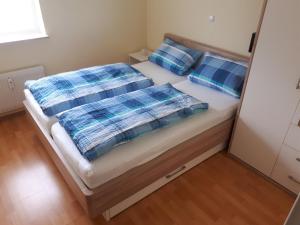 a bedroom with a bed with blue pillows at Ferienwohnung Nicole in Isny im Allgäu