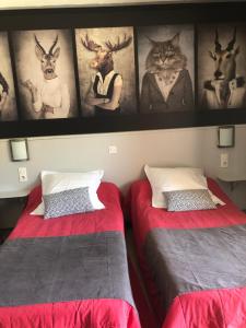 twee bedden in een kamer met foto's aan de muur bij Stella Marina in Galeria