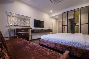 a hotel room with two beds and a flat screen tv at Wifi Boutique Hotel in George Town