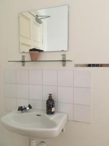 a white bathroom with a sink and a mirror at Morris Hotel in Örebro