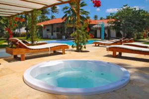 een zwembad met een hot tub in de tuin bij Tucano Pousada in Cumbuco