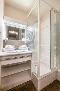 a white bathroom with a shower and a sink at Neige et Soleil in Montchavin