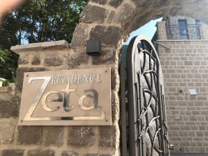 un panneau sur le côté d'un bâtiment avec une porte dans l'établissement Zeta Residence, à Donji Stoliv